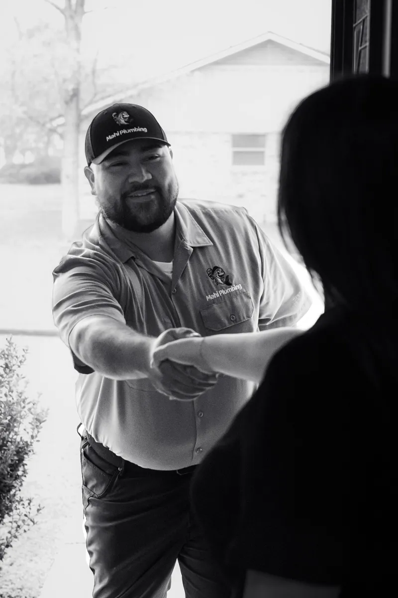 Mahi Plumbing plumber shaking hands with a homeowner at their front door